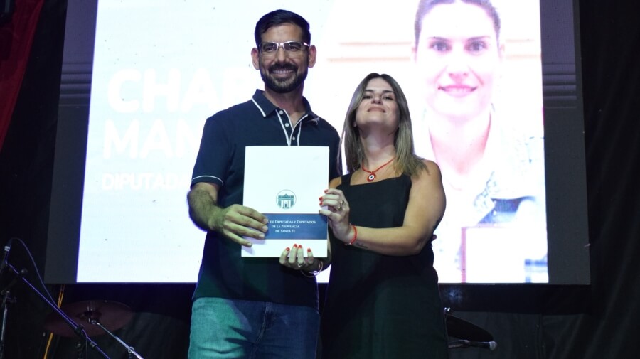 ntendente Iván Sánchez recibiendo la Declaratoria de Interés Provincial de manos de la diputada Charo Mancini durante la Fiesta de la Costa en Las Toscas.