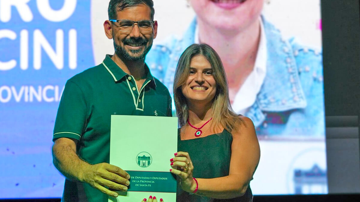 Charo Mancini entrega al intendente Iván Gastón Sánchez la Declaración de Interés provincial durante la Fiesta de la Costa en Las Toscas.