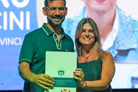 Charo Mancini entrega al intendente Iván Gastón Sánchez la Declaración de Interés provincial durante la Fiesta de la Costa en Las Toscas.
