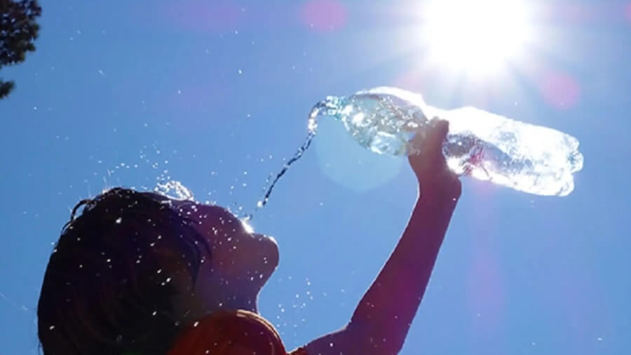 Persona hidratándose durante ola de calor en Santa Fe por alerta amarilla del SMN.