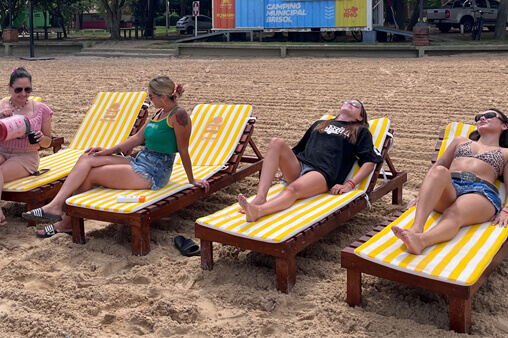 chicas relajadas disfrutando del sol y la playa en Romang usando reposeras del Camping Brisol
