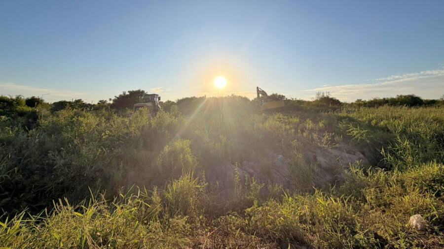 Maquinaria y personal municipal realizando tareas de limpieza y desmalezamiento en terrenos urbanos de Villa Ocampo.