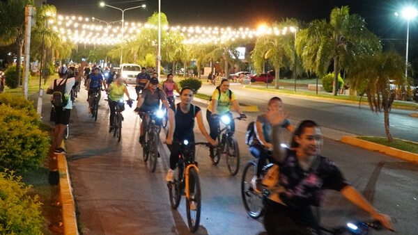 Grupo de ciclistas recorriendo distintos sectores urbanos durante la bicicleteada nocturna