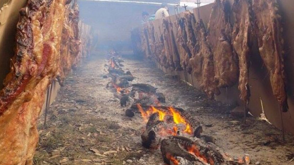 Costillares cocinándose a la estaca durante la Fiesta Regional del Asado en El Timbó, Avellaneda.