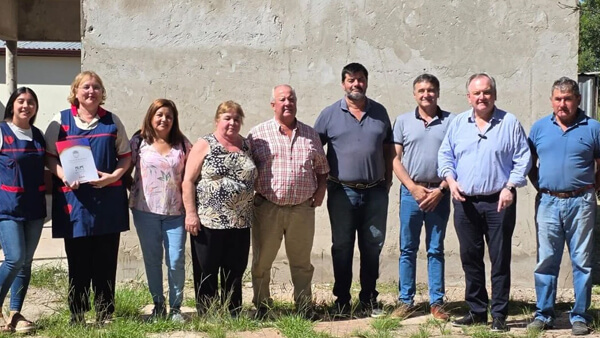 Michlig junto a directivos escolares en la entrega de fondos para infraestructura educativa en La Lucila.