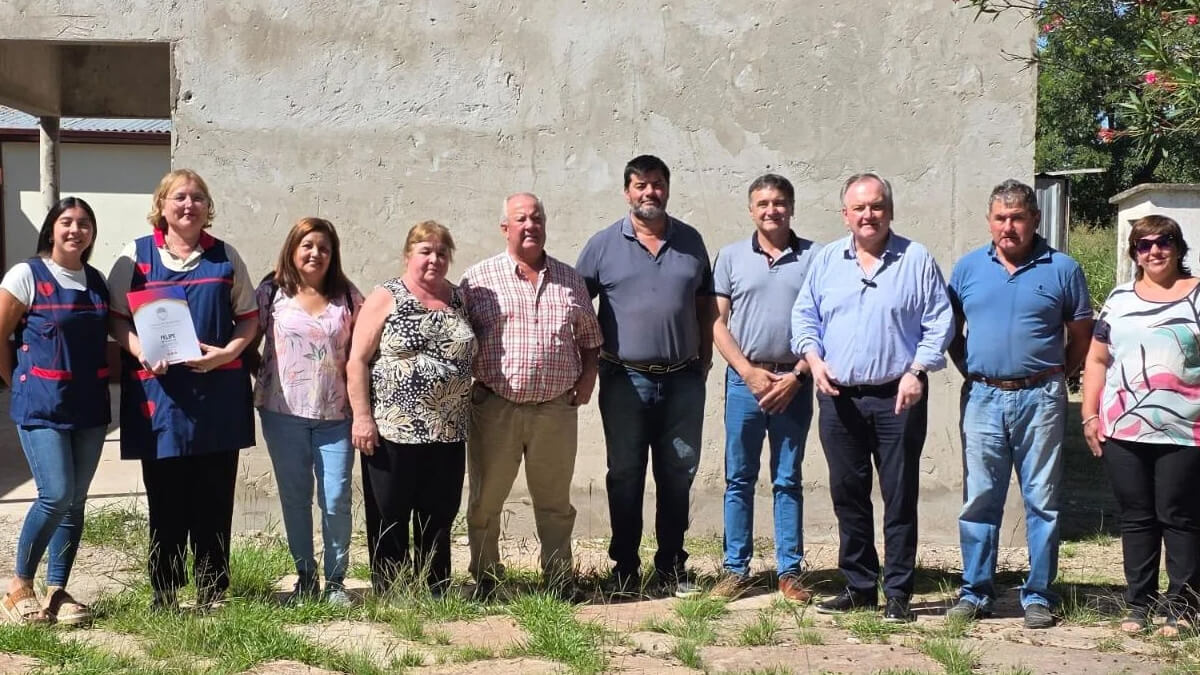 Michlig junto a directivos escolares en la entrega de fondos para infraestructura educativa en La Lucila.