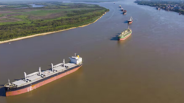 Vista de barcos de carga navegando por el río Paraná en la zona portuaria de Rosario, eje de la Hidrovía y del sistema exportador argentino.
