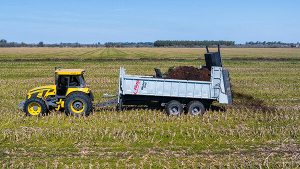 Aplicación de estiércol en campo de maíz durante ensayo agronómico para mejorar rendimiento y fertilidad del suelo