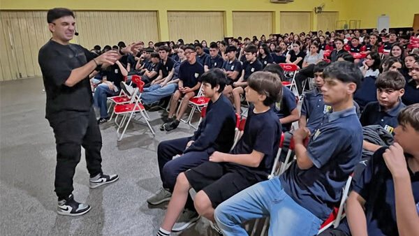 Ayrton Oviedo brindando charla de concientización ante estudiantes y docentes en Romang sobre bullying y adicciones