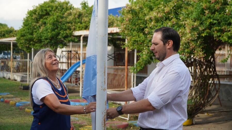 Intendente Cristian Marega junto a docente durante el izamiento de la bandera en el inicio de clases 2026 en Villa Ocampo