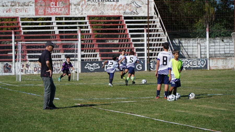 Momento de práctica en campo durante clínica de fútbol infanto juvenil en Villa Ocampo con entrenadores y niños