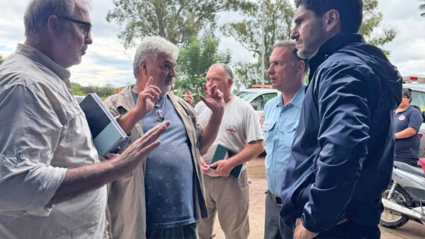 Pullaro dialogando con vecinos durante su recorrido por zonas afectadas por inundaciones en Villa Minetti