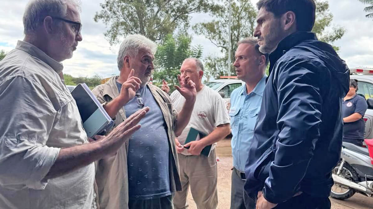 Pullaro dialogando con vecinos durante su recorrido por zonas afectadas por inundaciones en Villa Minetti