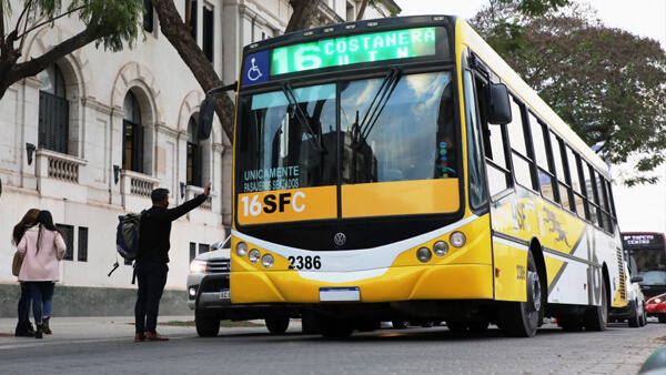 Transporte público en Santa Fe con colectivos urbanos en circulación y usuarios en paradas del sistema de transporte provincial
