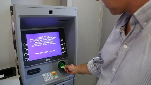 Persona retirando dinero de un cajero automático durante el cronograma de pago de haberes provinciales