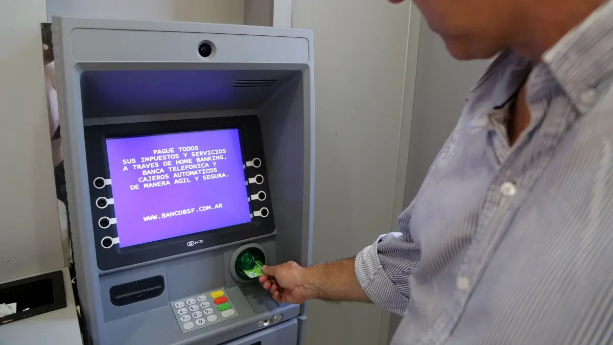 Persona retirando dinero de un cajero automático durante el cronograma de pago de haberes provinciales
