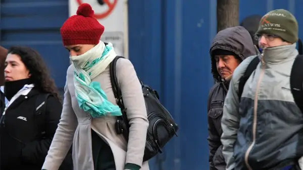 Personas caminando abrigadas por el descenso de temperatura