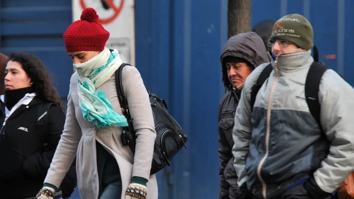 Personas caminando abrigadas por el descenso de temperatura