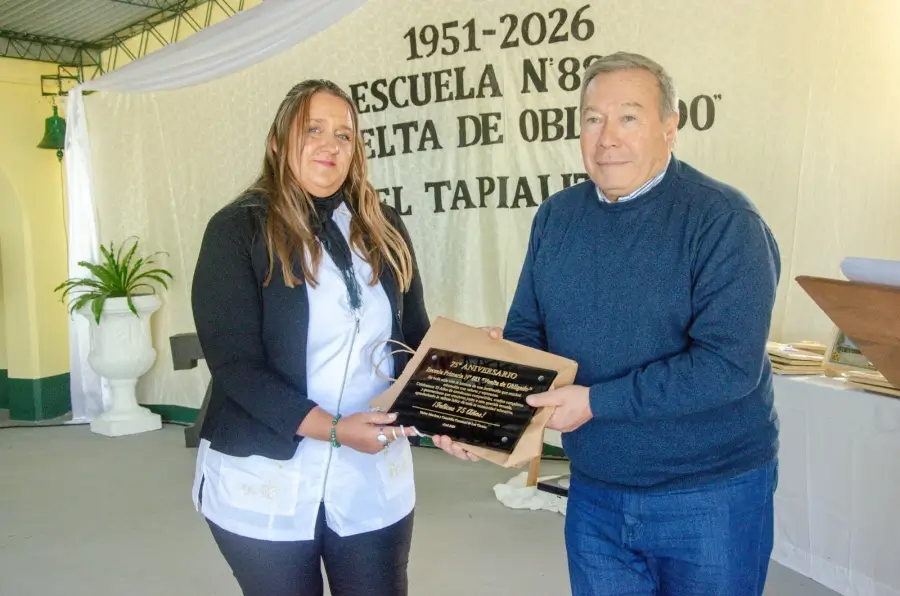 Walter Sánchez entrega una plaqueta durante el aniversario de la Escuela 883