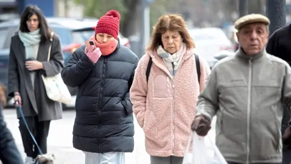 Personas abrigadas caminan por una calle de Santa Fe durante una jornada de intenso frío y bajas temperaturas.