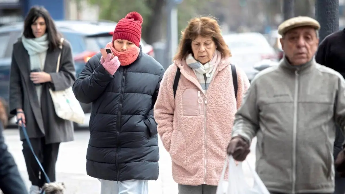 Personas abrigadas caminan por una calle de Santa Fe durante una jornada de intenso frío y bajas temperaturas.