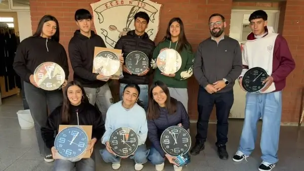 Sergio Chiqui Rojas junto a estudiantes de la escuela durante la entrega de los relojes de pared