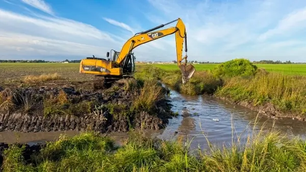 Maquinaria municipal realizando tareas de limpieza y rectificación de un canal en Avellaneda
