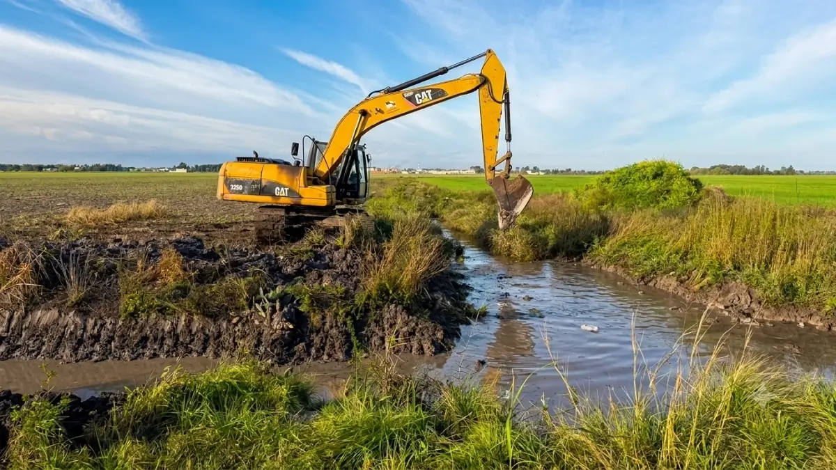 Maquinaria municipal realizando tareas de limpieza y rectificación de un canal en Avellaneda