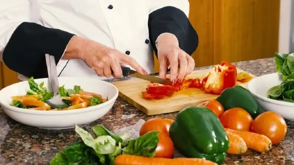Cocinera trabajando durante la preparación y manipulación de alimentos