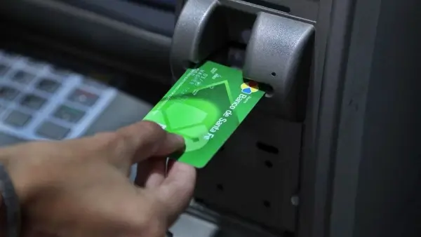 Trabajador retirando dinero de un cajero automático durante el cronograma de pago de haberes de Santa Fe