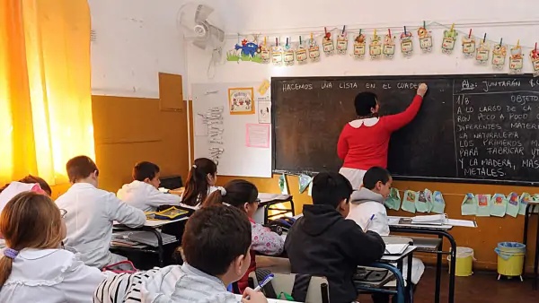Docente frente a sus alumnos en un aula escolar, ilustración de la noticia sobre el pago de Asistencia Perfecta en Santa Fe