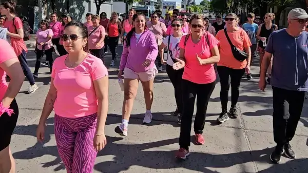 Participantes de una correcaminata con prendas rosas en una actividad de concientización sobre el cáncer de mama.