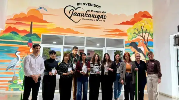Entrega de reconocimiento a los realizadores del mural Turis-Art, con la obra dedicada al Jaaukanigás de fondo.